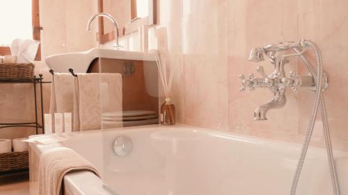 bañera blanca con grifo en el baño en Dimora Decò en Lugo