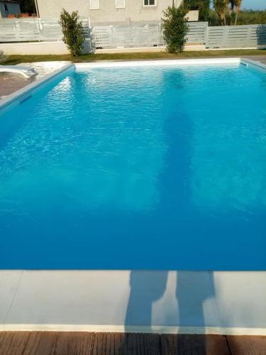 a blue swimming pool with a persons reflection in the water at LE TORRI DEL CILENTO in Santa Maria di Castellabate