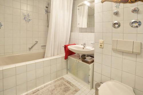 een badkamer met een wastafel, een toilet en een bad bij Bildstöckle in Sonthofen