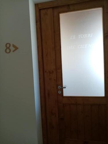 a wooden door in a room with a sign on it at LE TORRI DEL CILENTO in Santa Maria di Castellabate