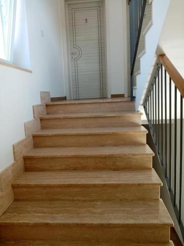a stairway with wooden steps leading to a door at LE TORRI DEL CILENTO in Santa Maria di Castellabate