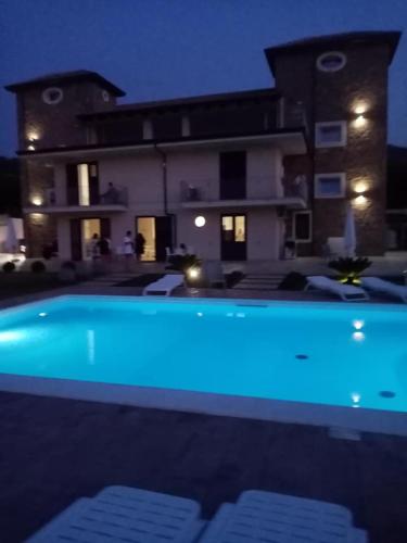 a swimming pool in front of a house at night at LE TORRI DEL CILENTO in Santa Maria di Castellabate