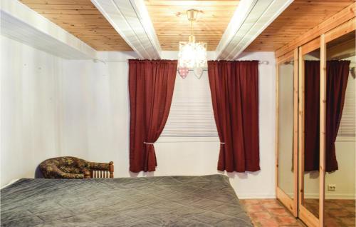 a bedroom with a bed and red curtains at Nice Apartment In Giske With 3 Bedrooms And Wifi in Gjuv