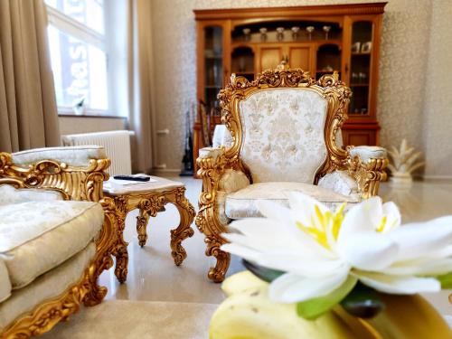 a room with two chairs and a white flower at Madonna Apartments in Karlovy Vary