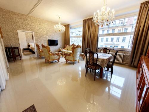 a dining room and living room with a table and chairs at Madonna Apartments in Karlovy Vary