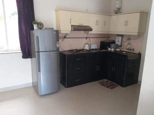 a kitchen with a stainless steel refrigerator and black cabinets at River view apartments in Cavelossim