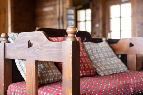 a wooden bed with red sheets and pillows at Hôtel Les Balcons Village in Belle Plagne