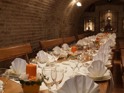 a long table with white plates and wine glasses at Podrumi Kolar "Suza Baranje" in Kneževi Vinogradi