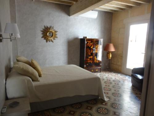 ein Schlafzimmer mit einem weißen Bett und einem Fenster in der Unterkunft La Fleury in Arles