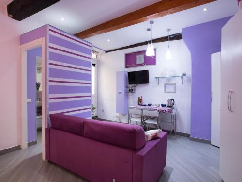 un soggiorno con divano viola e tavolo di I Coralli rooms & apartments a Monterosso al Mare
