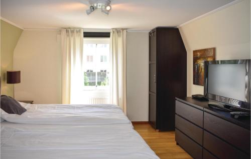 Gorgeous Apartment In Karlskrona With Wifi في كارلسكرونا: غرفة نوم بسرير وتلفزيون بشاشة مسطحة