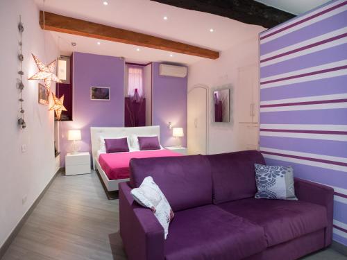 ein lila Wohnzimmer mit einem Sofa und einem Bett in der Unterkunft I Coralli rooms & apartments in Monterosso al Mare