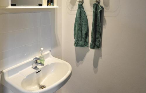 a bathroom with a sink and green towels on a wall at 4 Bedroom Gorgeous Home In Lindesberg in Lindesberg