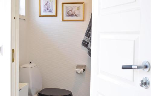 a bathroom with a toilet and two pictures on the wall at 1 Bedroom Stunning Home In Grevie in Grevie