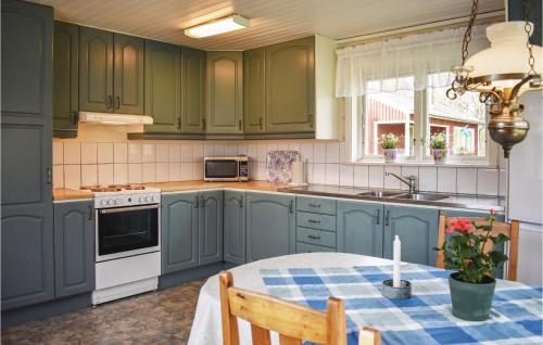 a kitchen with green cabinets and a table with a candle at Pet Friendly Home In Listerby in Listerby