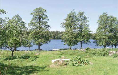 a grassy field with trees and a lake at Awesome Home In Ryd With House Sea View in Ryd