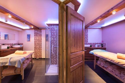 a bathroom with two beds and a shower at Hôtel Les Balcons Village in Belle Plagne