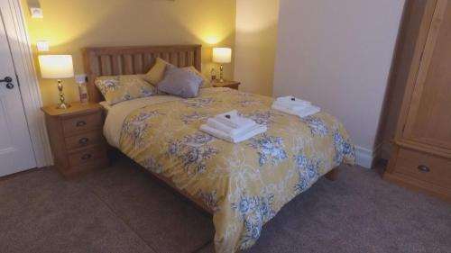 a bedroom with a bed with two towels on it at The Rose Luxury Self Catering Accommodation in Armagh