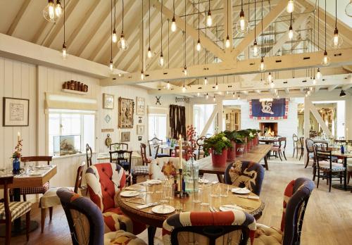 a restaurant with tables and chairs and a fireplace at The Goodwood Hotel in Chichester