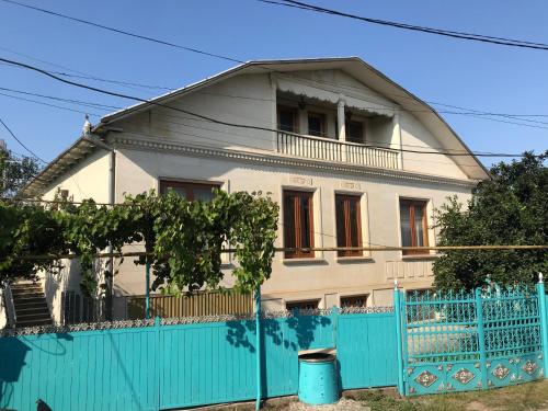 a white house with a blue fence in front of it at Wooden Museum in Kutaisi