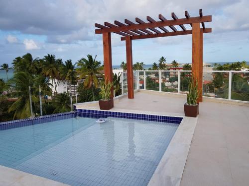 a swimming pool with a pergola on top of a building at MAKAIBA FLATS De Luxo in Porto De Galinhas