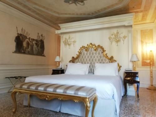 a bedroom with a large bed with a gold frame at Ca' Bonfadini Historic Experience in Venice