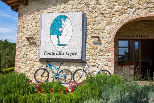 two bikes parked outside of a stone building at Spa Resort Fonte Alla Lepre in Riparbella