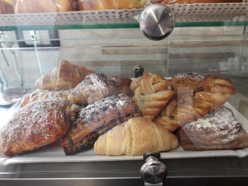 a display case with a bunch of different types of pastries at B&B Scirocco House in Oliveri