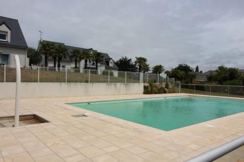 une piscine devant une maison dans l'établissement Gite - Le Green - Maison avec Terrasse dans parc avec piscine proche plages et Golf, à Pléneuf-Val-André