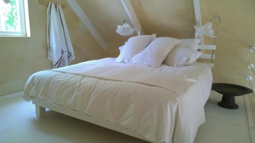 Cama blanca con sábanas y almohadas blancas en The Cottage 39 Steyn en Barrydale