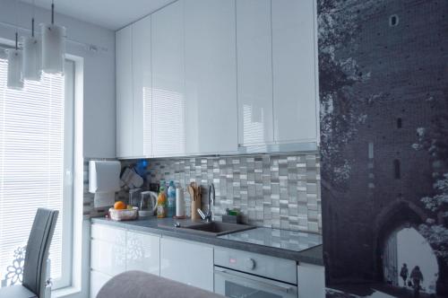 a kitchen with white cabinets and a sink at Apartament Marzanna II in Sandomierz