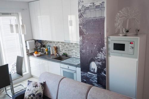 a kitchen with a couch and a sink and a microwave at Apartament Marzanna II in Sandomierz