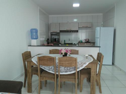 サン・フランシスコ・ド・スルにあるApartamento Praia Grande - São Francisco do Sul - Scのテーブルと椅子、冷蔵庫のあるキッチン