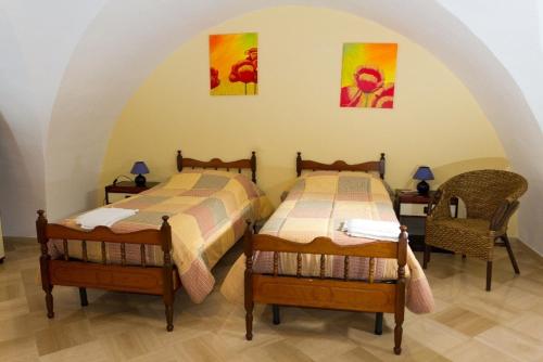 two twin beds in a room with two chairs at Corte Delle Moline in San Cesario di Lecce