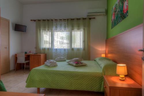 a bedroom with a green bed and a desk at AquariumResidence in San Pietro in Bevagna
