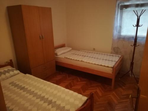 2 camas en una habitación pequeña con ventana en Apartman Lidija en Livno