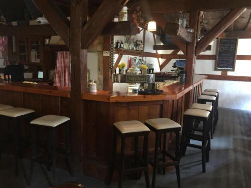 a bar in a restaurant with a row of stools at Altstadtpension Zirndorf in Zirndorf