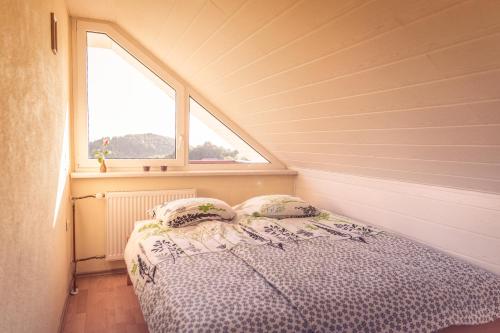 Ce lit se trouve dans une petite chambre dotée d'une fenêtre. dans l'établissement Vineyard Cottage Urban, à Mirna