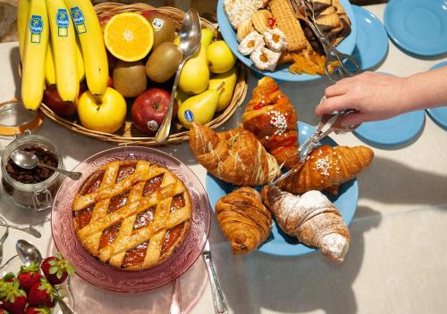 a table topped with plates of bread and pastries and fruit at Terre Di Himera in Buonfornello