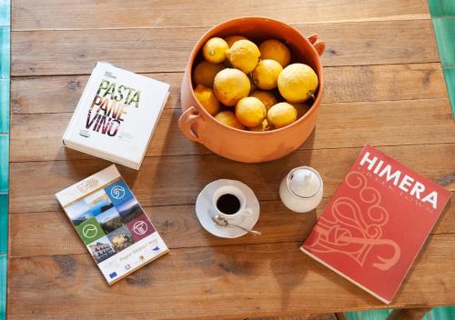 a table with a bowl of lemons and a cup of coffee at Terre Di Himera in Buonfornello