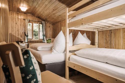 three bunk beds in a room with wooden walls at Berghütte Hochpillberg in Pill