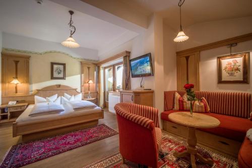 a hotel room with a bed and a couch at Ferienhotel Sonnenhof in Zell am Ziller