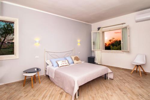 a white bedroom with a bed and two windows at Luca's Rooms in Valledoria