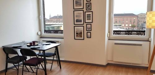 une salle à manger avec une table et deux fenêtres dans l'établissement Le Bas Rebberg - Face Gare, à Mulhouse