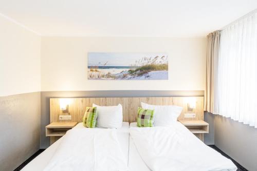 1 Schlafzimmer mit 2 Betten und 2 Tischen in der Unterkunft Gästehaus Alexandra in Cuxhaven
