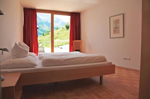 ワースにあるCaroline´s Appartement in Warth am Arlbergの大きな窓のあるベッドのある寝室