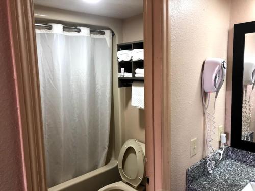 een badkamer met een douche en een toilet met een telefoon bij Legacy Inn - Gallatin in Gallatin