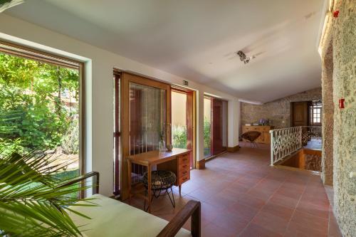 an open living room with a table and chairs at Casa do Eido - sustainable living & nature experiences Gerês in Geres