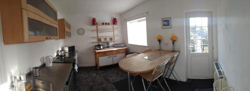 a small kitchen with a wooden table in a room at Beach Road in Margate