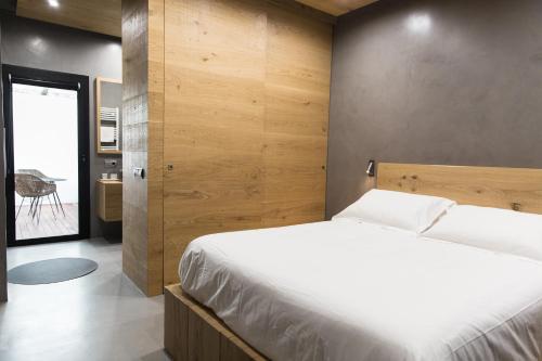um quarto com uma cama e uma parede de madeira em El Recer de Masia Serra em Cantallops